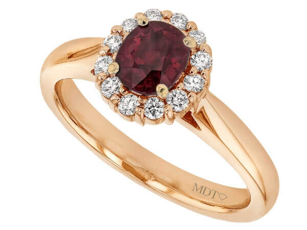 An oval ruby and diamond engagement ring in rose gold.
