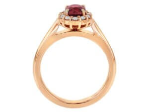 An exquisite engagement ring featuring an oval ruby surrounded by a diamond halo, set in stunning rose gold.