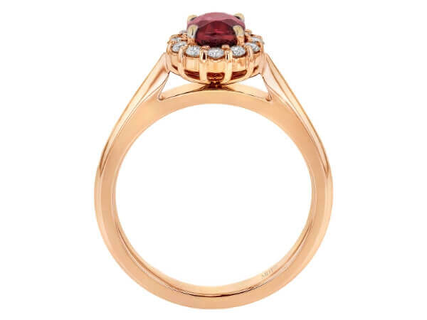 An exquisite engagement ring featuring an oval ruby surrounded by a diamond halo, set in stunning rose gold.