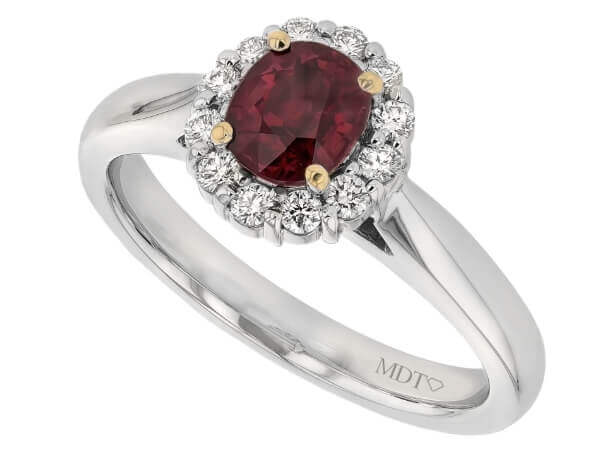 An elegant oval ruby and diamond halo engagement ring.