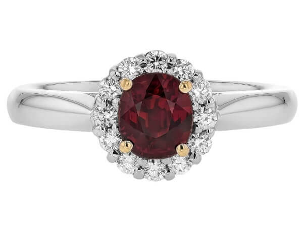 A stunning oval ruby engagement ring adorned with a sparkling diamond halo, set in elegant white gold.