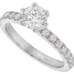 A white gold diamond engagement ring with six claws and claw set diamond band.