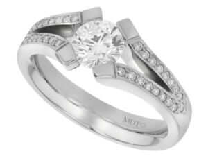 A white gold engagement ring with an oval cut diamond in a tension set.
