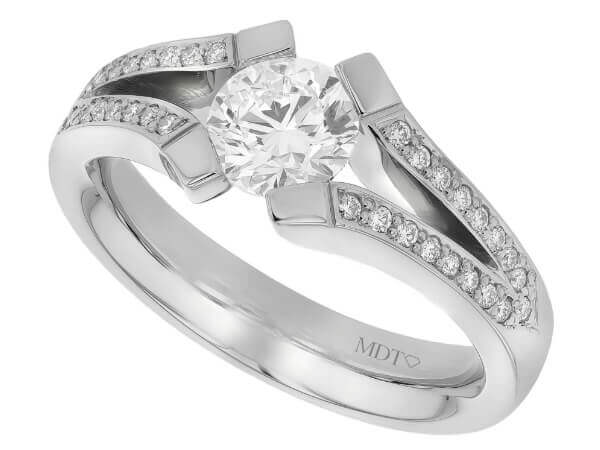 A white gold engagement ring with an oval cut diamond in a tension set.