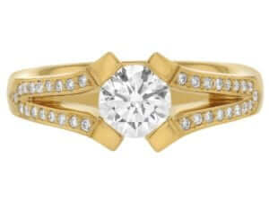 A yellow gold engagement ring with an oval cut diamond set on a split band.