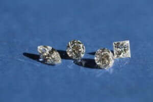 Four loose diamonds on blue background.