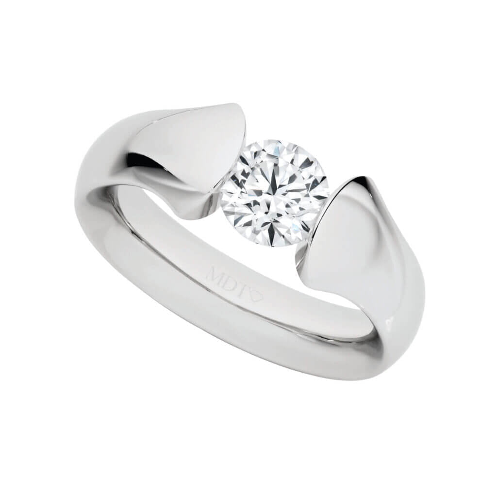 A White Gold ring with a large round, white diamond centrepiece, featuring a modern, curved tension set design. The ring is marked with "MDT" and epitomizes the sophisticated allure of MDT DESIGN's unique engagement rings.