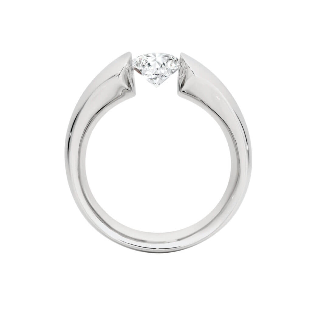 A minimalist ring with a single diamond held by a sleek, modern setting, viewed from the side. This piece is part of MDT DESIGN's collection of unique engagement rings and tension set designs