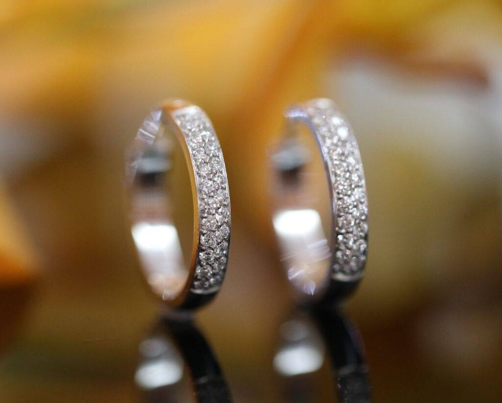 a pair of diamond hoop earrings featuring pave set diamonds