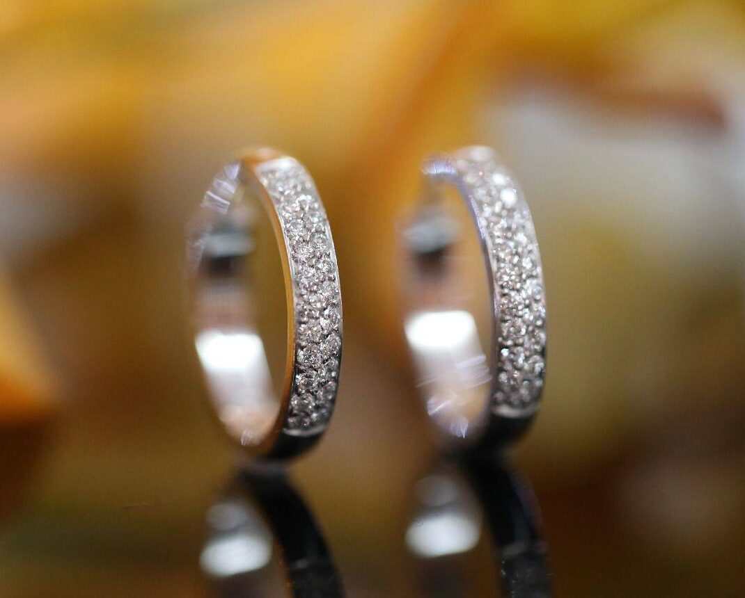 a pair of diamond hoop earrings featuring pave set diamonds