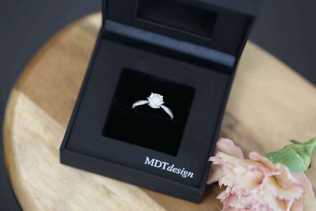 A black MDT DESIGN ring box featuring an MDT DESIGN handmade solitare engagement ring