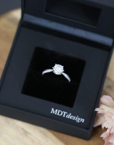 A black MDT DESIGN ring box featuring an MDT DESIGN handmade solitare engagement ring