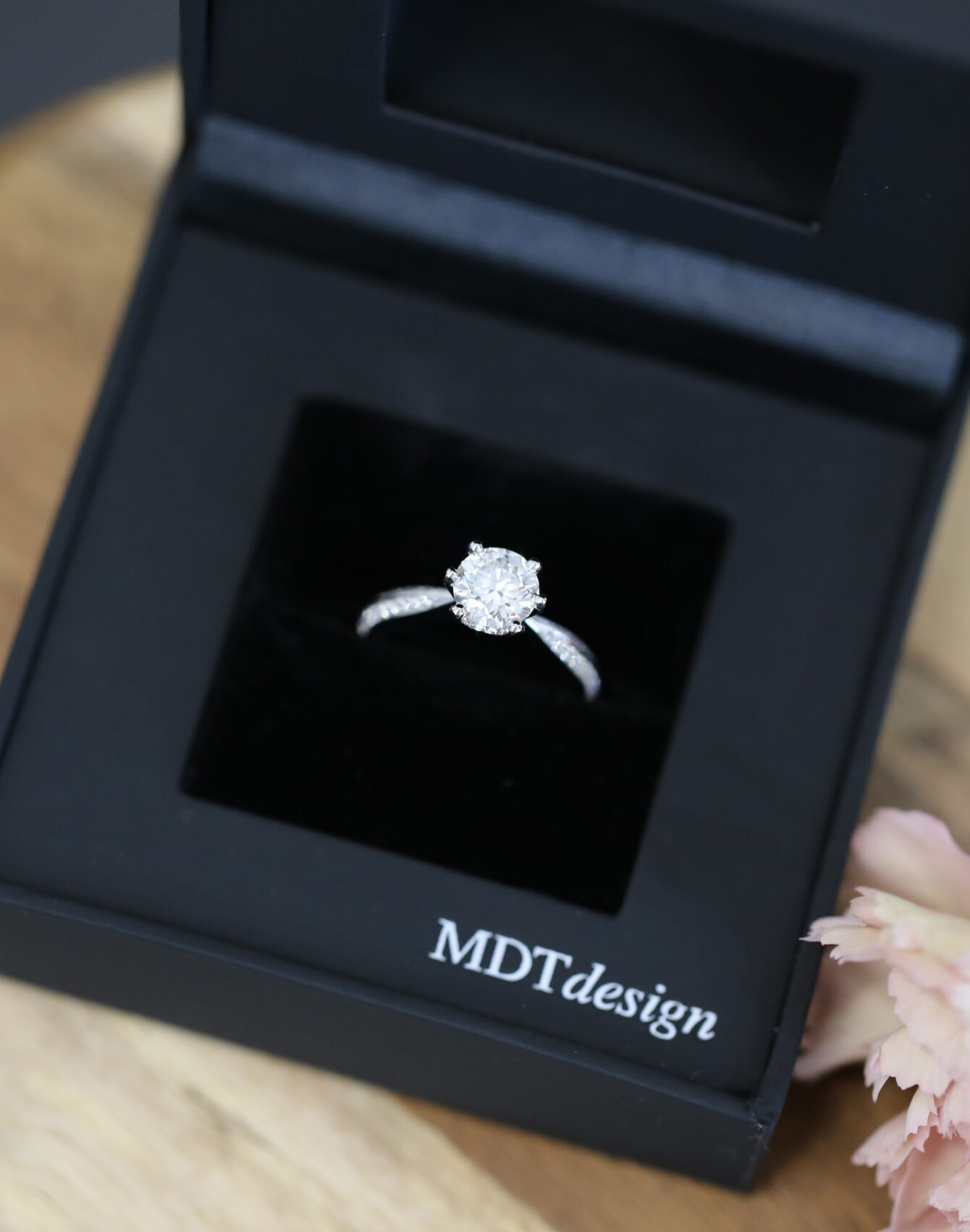 A black MDT DESIGN ring box featuring an MDT DESIGN handmade solitare engagement ring