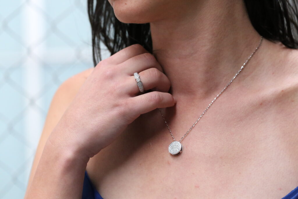 Collection of MDT DESIGN handmade jewellery worn by a woman. Including a diamond necklace and a diamond engagement ring
