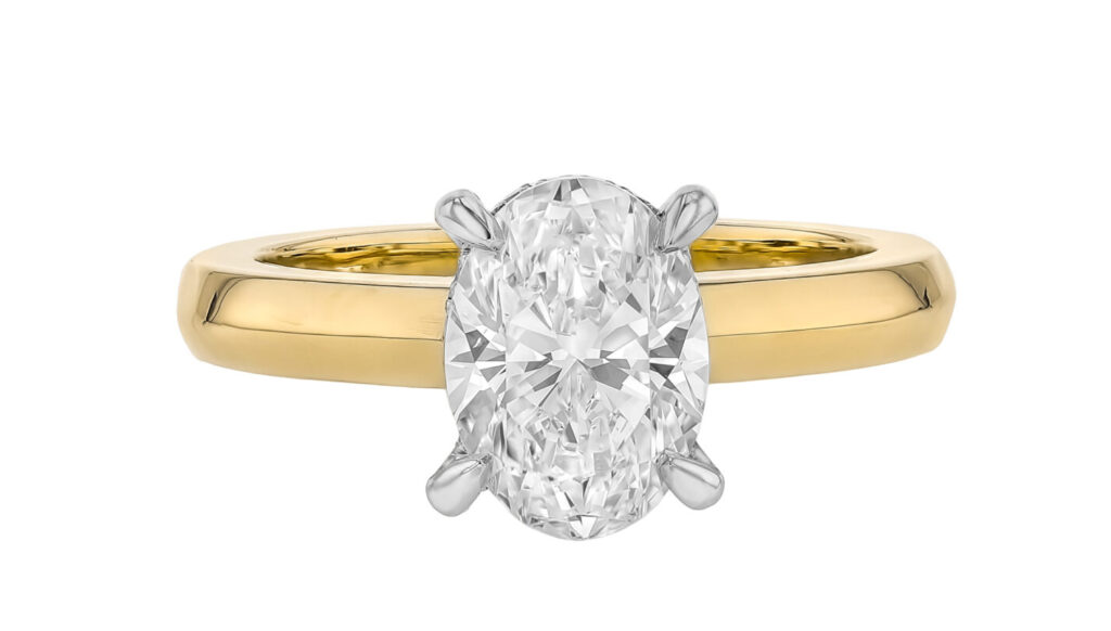 a yellow gold diamond engagement ring featuring a oval diamond set with four platinum claws