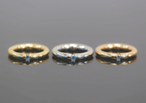 rings with 18CT Rose Gold, White Gold and Yellow Gold. Each a tension set ring with a treated blue diamond.
