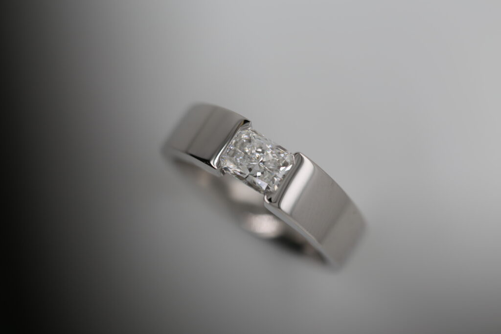 radiant cut diamond ring, tension set into platinum or white gold colour metal