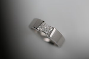 radiant cut diamond ring, tension set into platinum or white gold colour metal