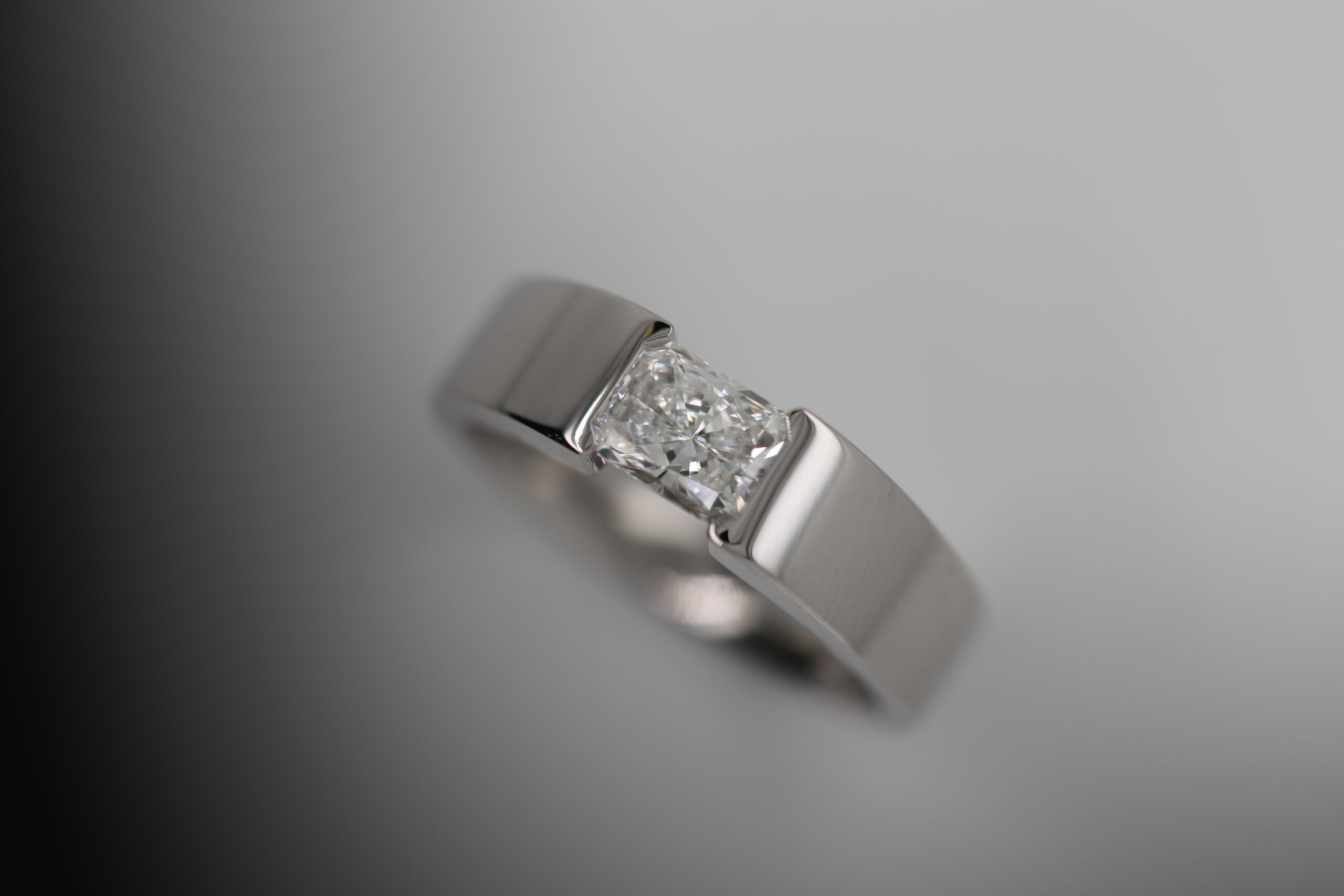 radiant cut diamond ring, tension set into platinum or white gold colour metal