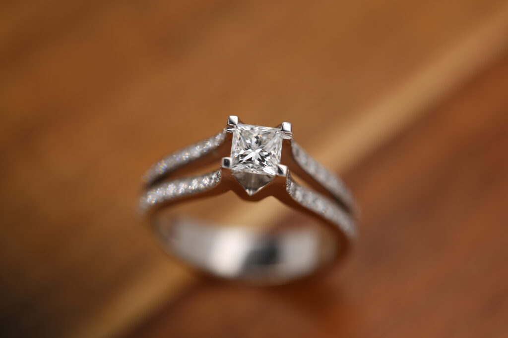 A unique engagement ring, handmade in white gold, in a split diamonds set band and a natural princess cut diamond at it's centre