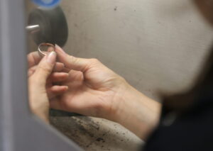over the shoulder view of a jeweller polishing a ring on a state of the art polishing machine in an onsite jewellery workshop