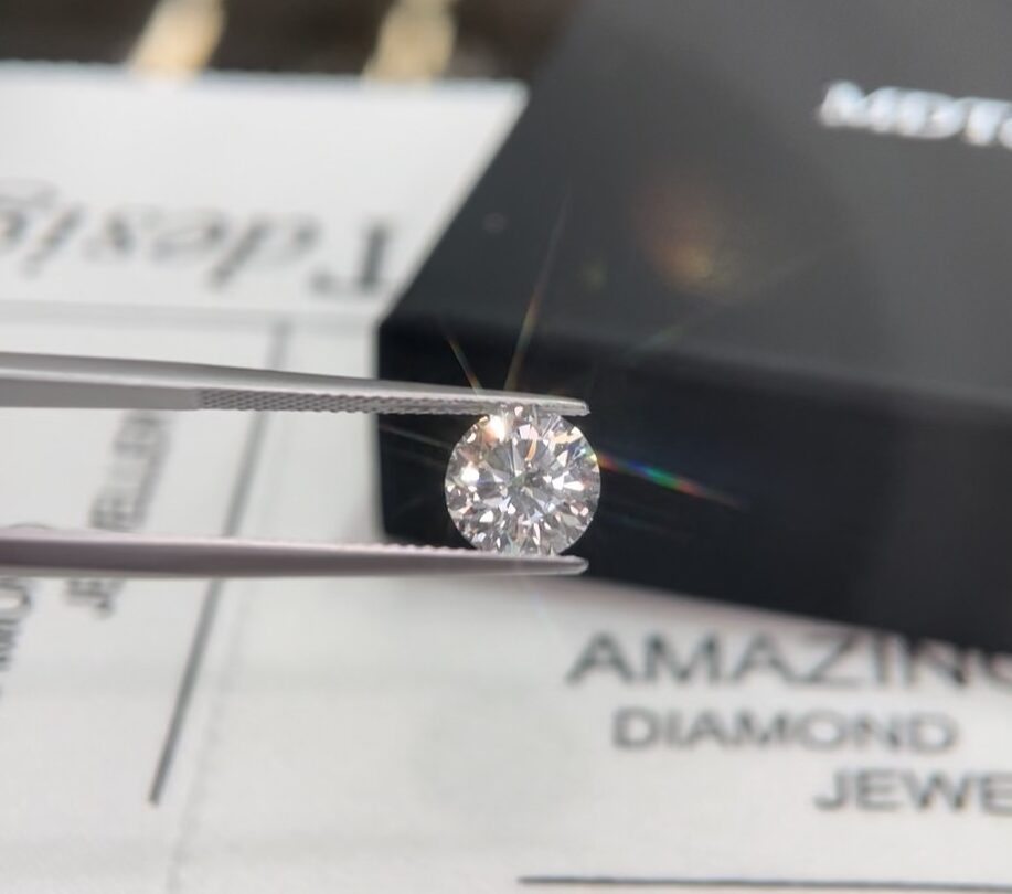 round brilliant cut white Diamond being held in tweezers to be inspected