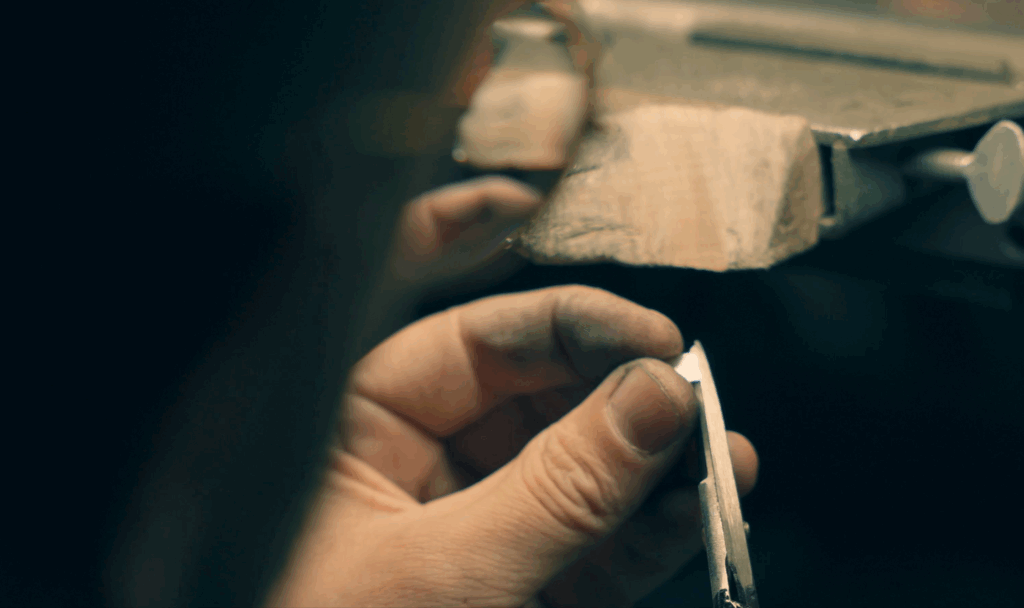 Visual of a jewellery working with a silver colour precious metal in a Melbourne Jewellery Workshop