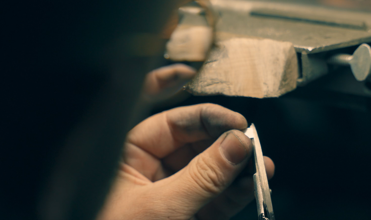 Visual of a jewellery working with a silver colour precious metal in a Melbourne Jewellery Workshop