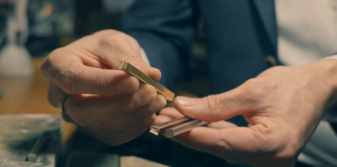 hands holding three bars of precious metal. Appealingly platinum, white, rose and yellow gold.