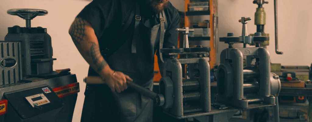 jeweller rolls down metal for custom design ring
