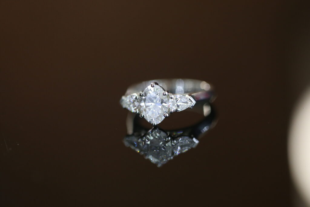 oval lab grown diamond trilogy engagement ring with pear shaped side stones in white gold setting