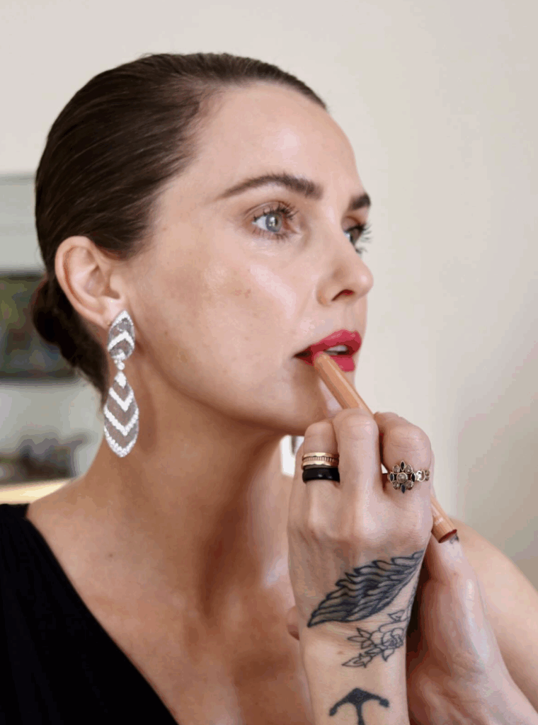 behind the scenes, makeup artist Keri Russell wearing layered white gold diamond drop earrings, having lipstick applied, for the Actor Awards red carpet.