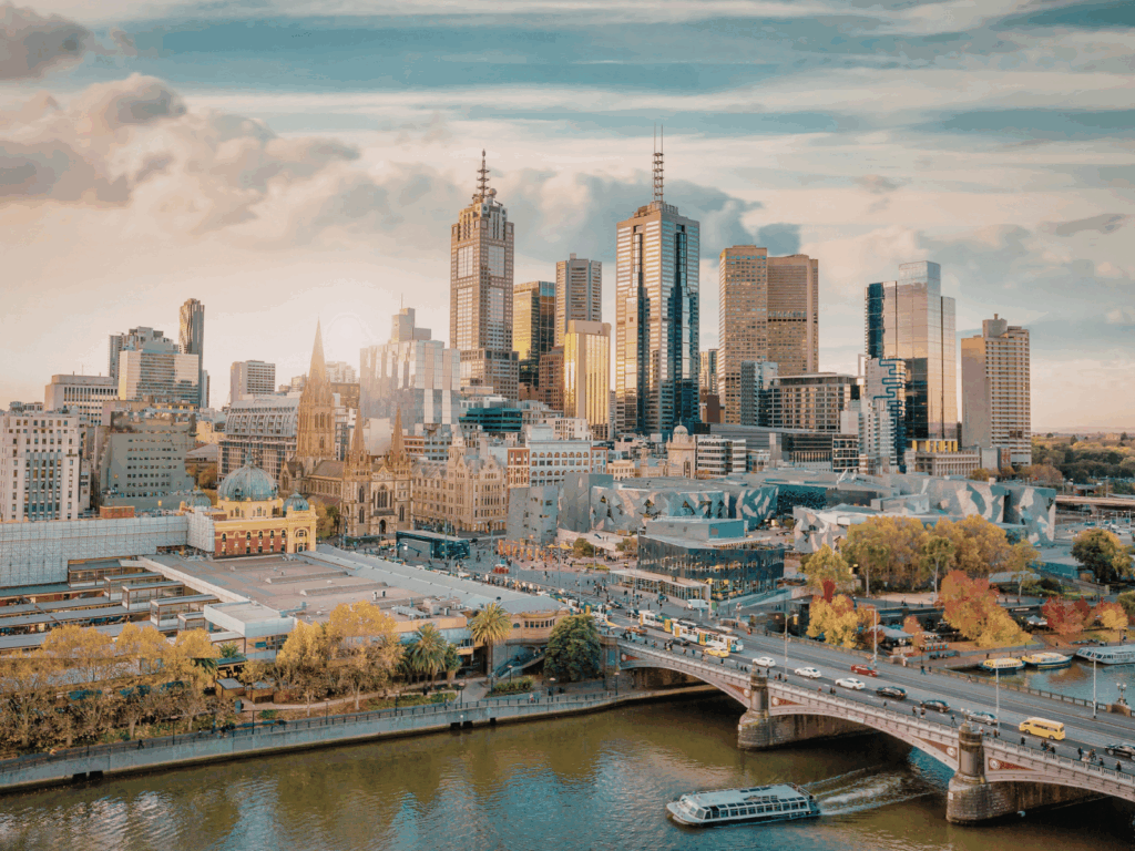 Melbourne city skyline with the Yarra River, Princes Bridge and Flinders Street Station at sunset.