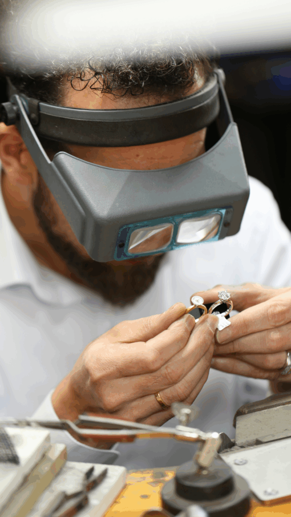 kosta theochari master jeweller from Melbourne jewellery boutique MDT DESIGN, comparing two rings with a head set on.