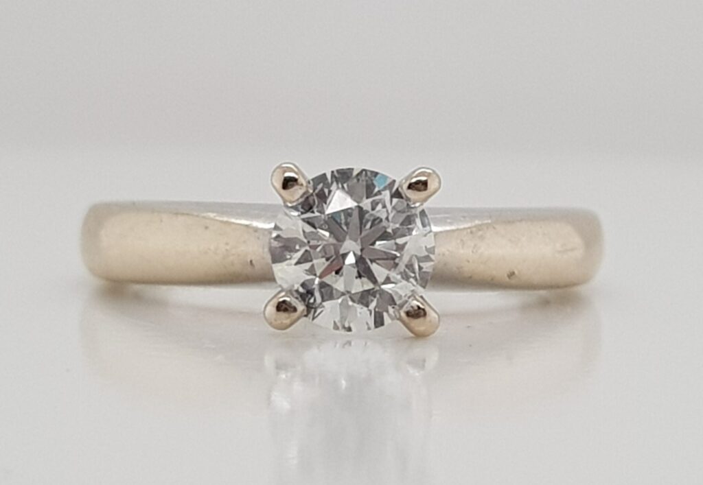 Front view of a white gold diamond engagement ring showing the natural warmer colour of the white gold beneath worn rhodium plating.